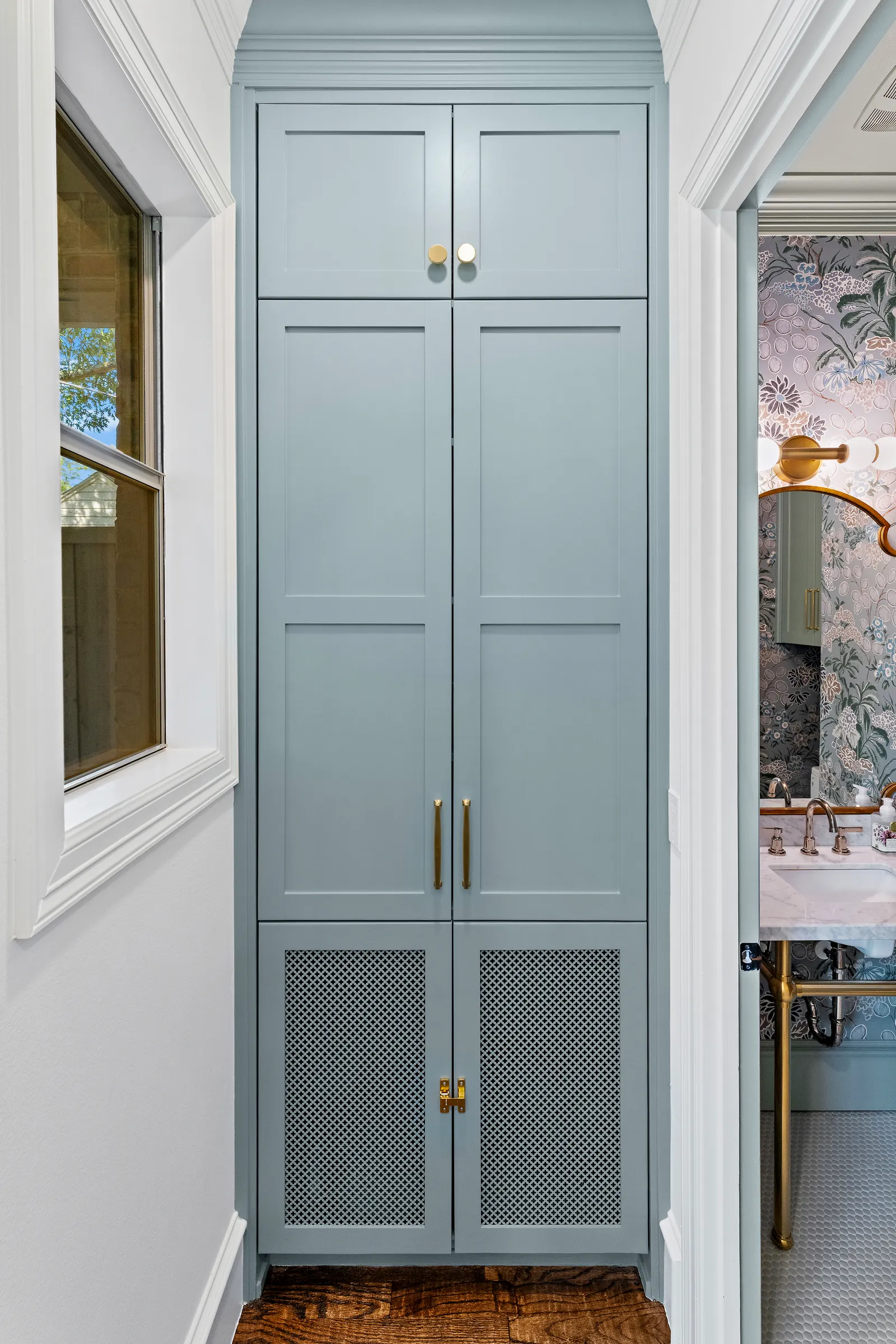 Light blue pantry cabinet with mesh doors and brass pulls at Revere Pl. in Lakewood