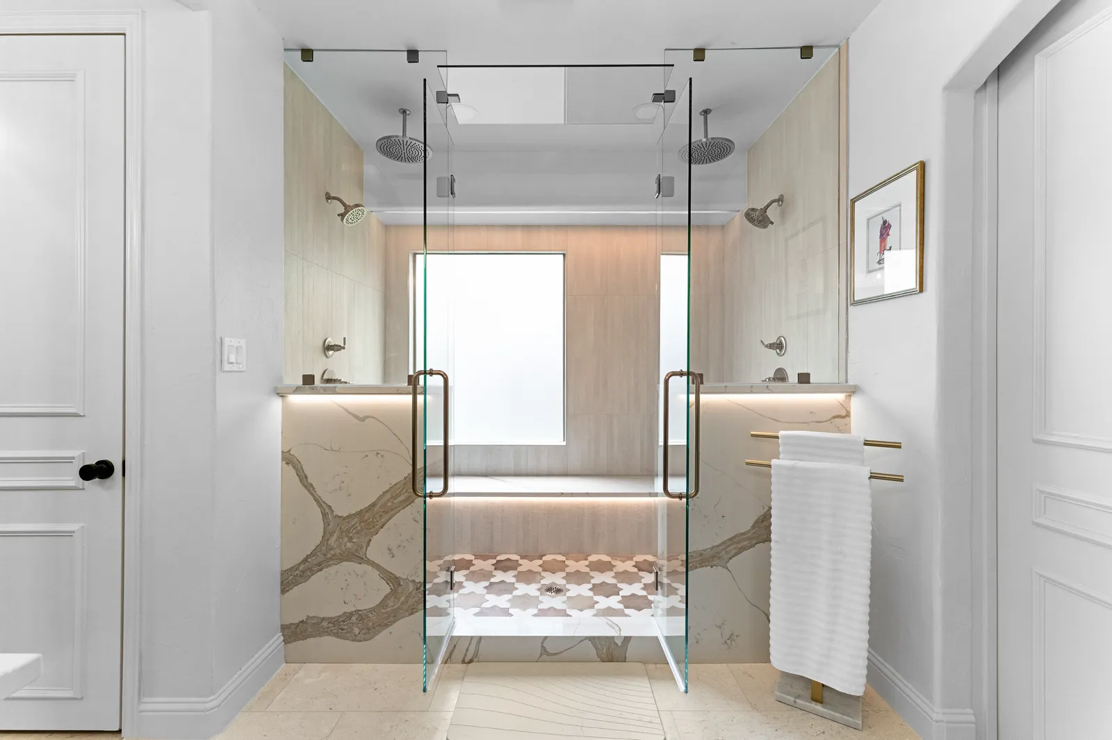 Primary bathroom at Shady Point Dr in Plano after the remodel by Renovation Sells Dallas: glass walk-in shower with dual rain heads, a built-in bench, stone slab walls, and a mosaic tile floor