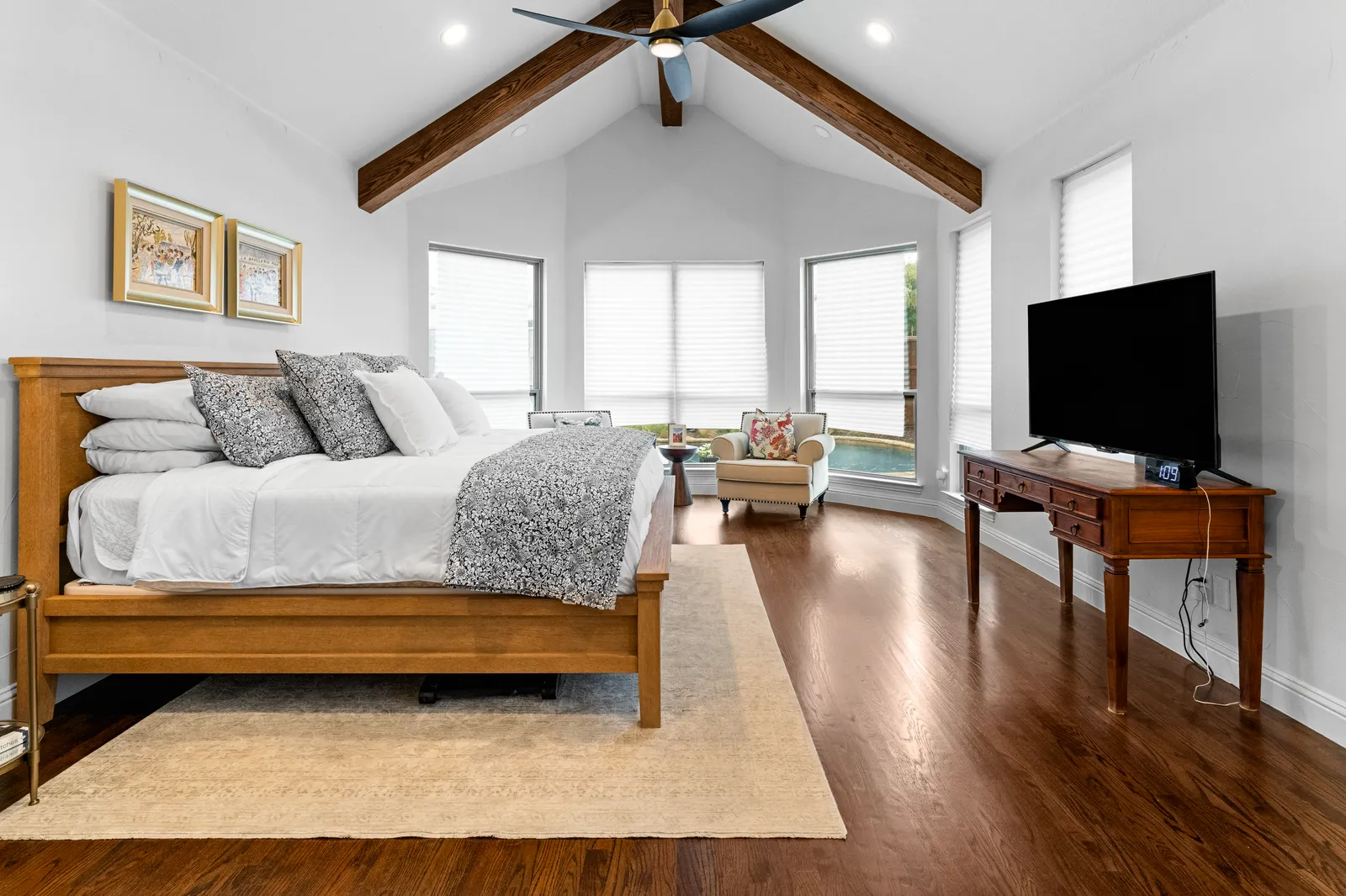 Primary bedroom with vaulted ceiling beams at Shady Point Dr in Plano, TX after the remodel